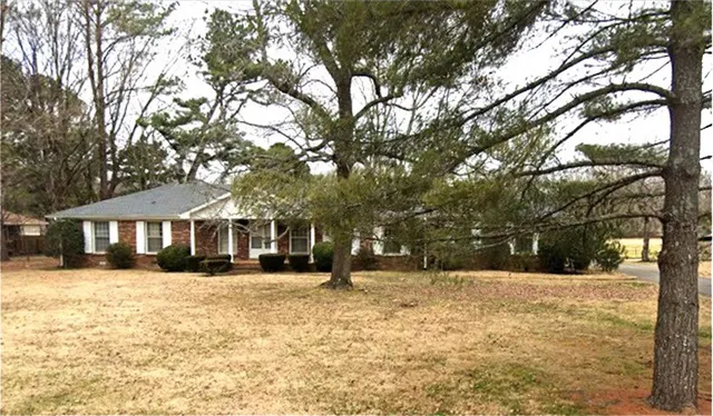 a front view of a house with a yard covered in snow