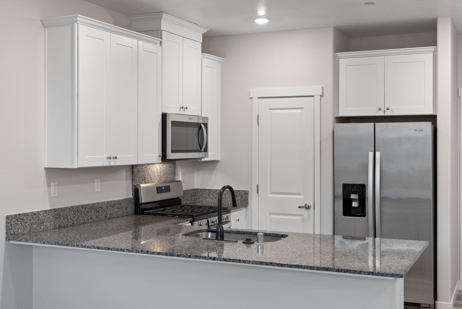 3286 New York Road West Sacramento, CA 95691 - Photo 17 of 22 a kitchen with granite countertop a refrigerator a stove and white cabinets