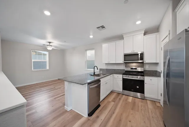 a kitchen with stainless steel appliances granite countertop a sink stove and refrigerator