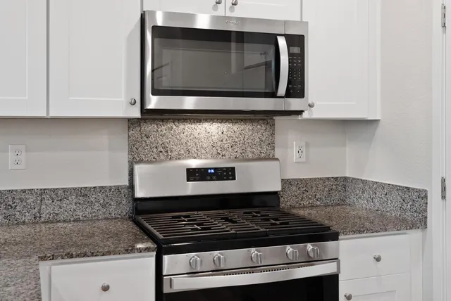a stove top oven sitting inside of a kitchen