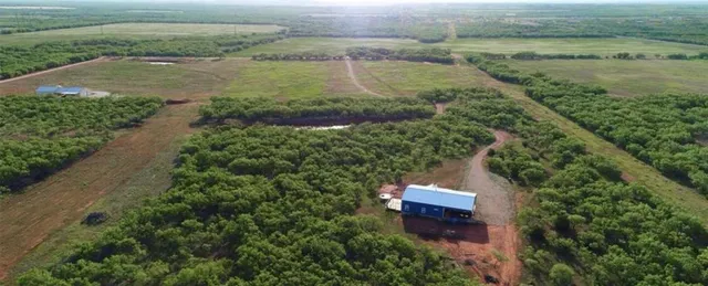 an aerial view of a house with a yard and lake view