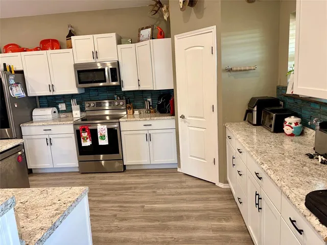 a kitchen with a refrigerator and a stove top oven