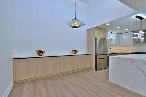 a kitchen with stainless steel appliances granite countertop a refrigerator a sink and a stove with wooden floor