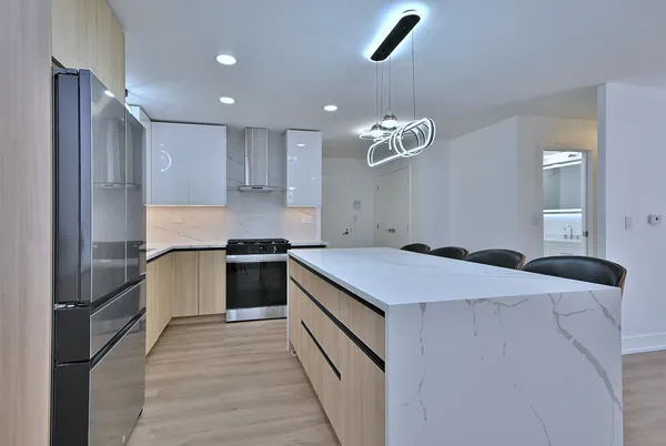 a kitchen that has a lot of cabinets and wooden floor