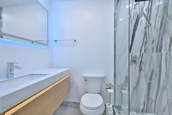 a bathroom with a sink a toilet and shower