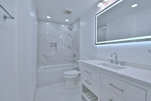 a bathroom with a sink a mirror a vanity and a shower
