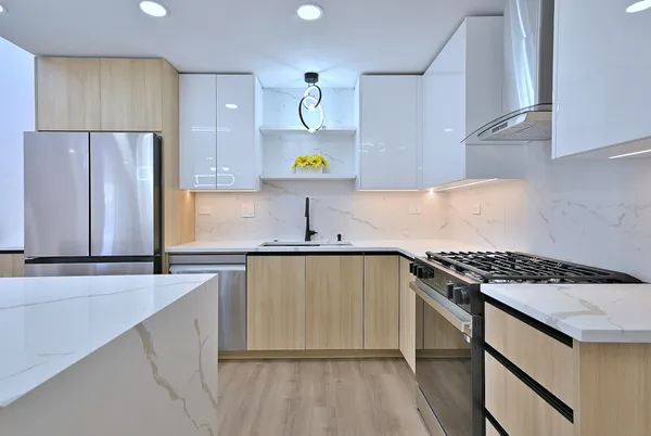 a kitchen with stainless steel appliances granite countertop a sink stove and refrigerator