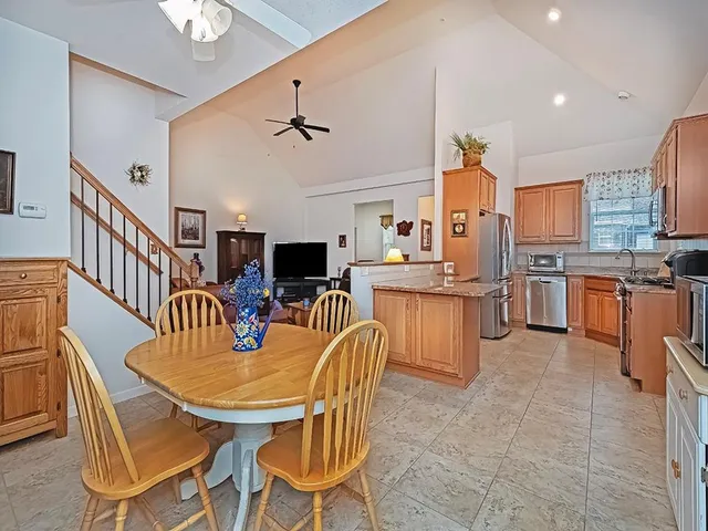 a dining room with stainless steel appliances a table and chairs