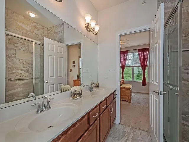 a bathroom with a double vanity sink a mirror and a shower