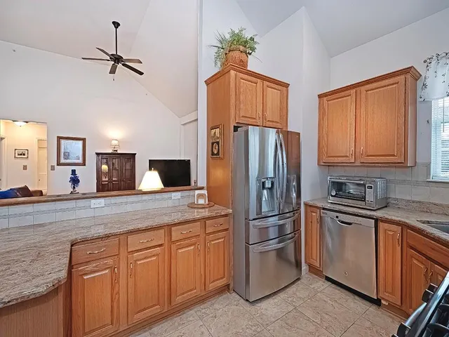 a kitchen with stainless steel appliances granite countertop a refrigerator and a sink