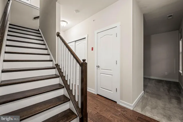 a view of a hallway with wooden floor and staircase