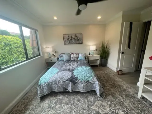 a spacious bedroom with a bed and wooden floor