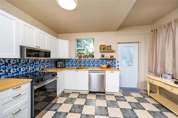 a kitchen with a checkered floor and white appliances