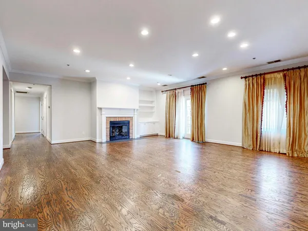 an empty room with wooden floor and fireplace
