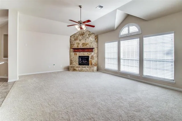 an empty room with windows and fireplace