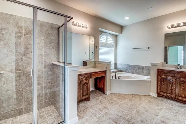 a en suite bathroom with a tub sink and mirror