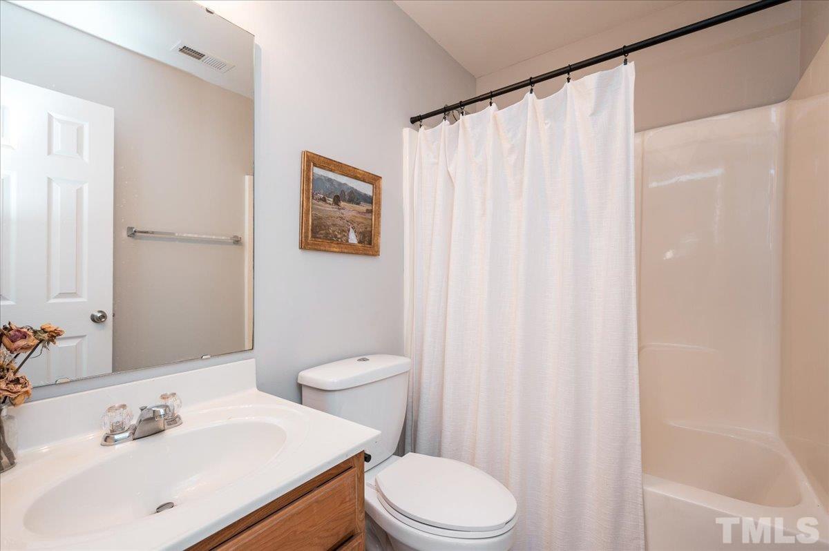 1645 Extine Lane Raleigh, NC 27610 - Photo 14 of 18 a bathroom with a sink a toilet and shower curtain