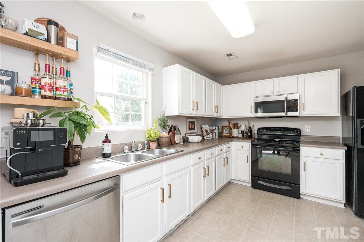 1645 Extine Lane Raleigh, NC 27610 - Photo 6 of 18 a kitchen with stainless steel appliances granite countertop a stove a sink and a microwave