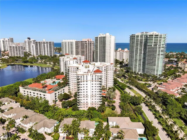 an aerial view of a houses with greenery space and a road