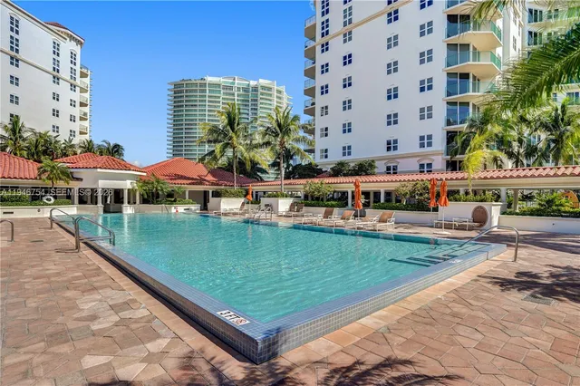 a view of a swimming pool with a bench and trees