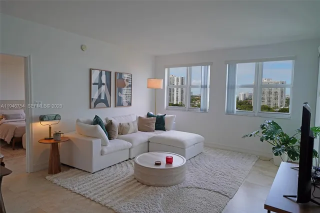 a living room with furniture a rug and a potted plant