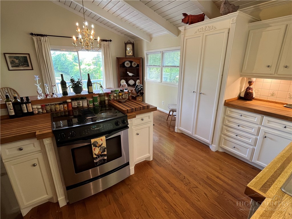 638 Ridge Road Glade Valley, NC 28627 - Photo 14 of 44 a kitchen with stainless steel appliances wooden floor sink and wooden cabinets