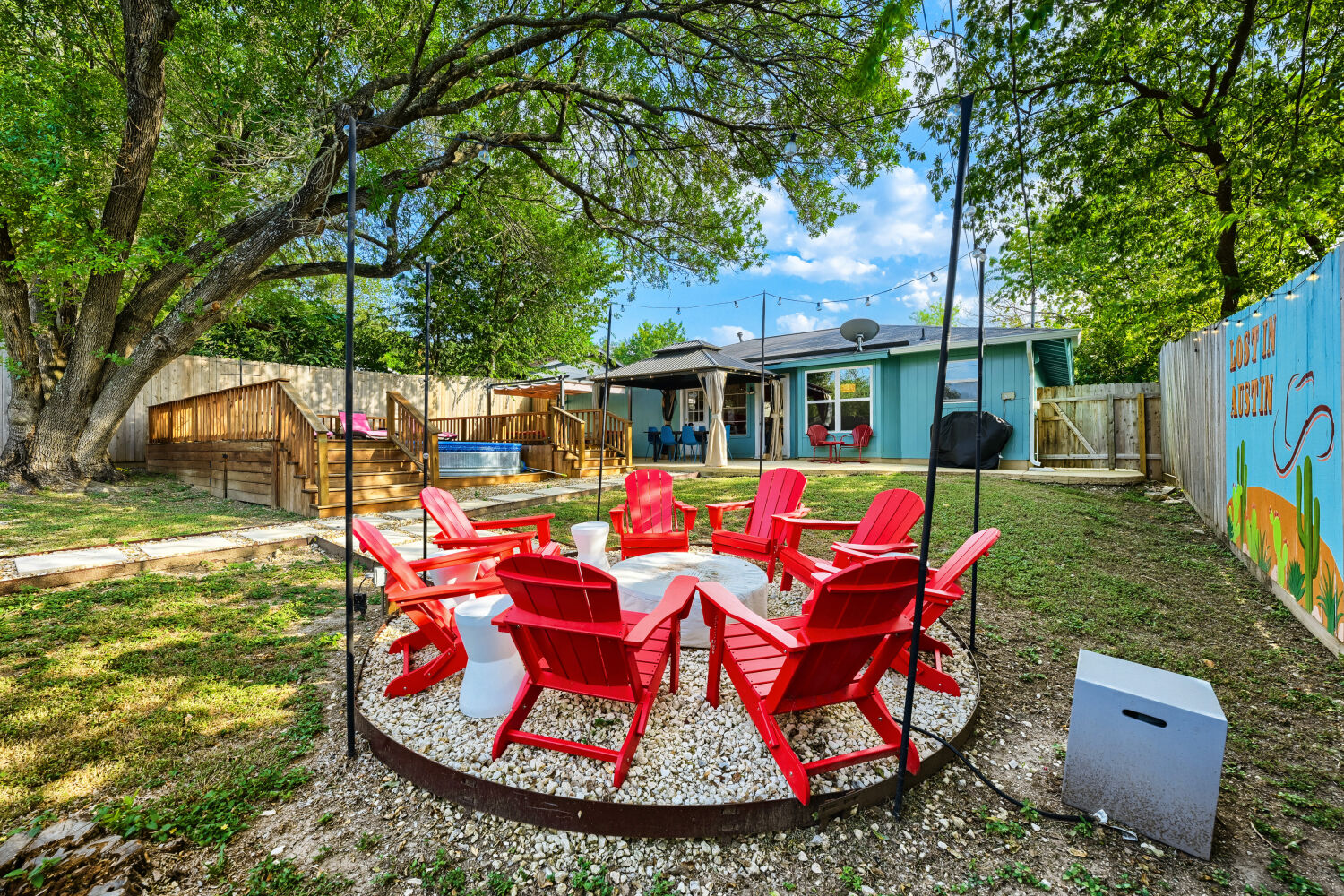 3410 Plantation Road Austin, TX 78745 - Photo 31 of 33 An inviting backyard oasis offers a comfortable fire pit area and a raised deck with a hot tub, perfect for relaxation.