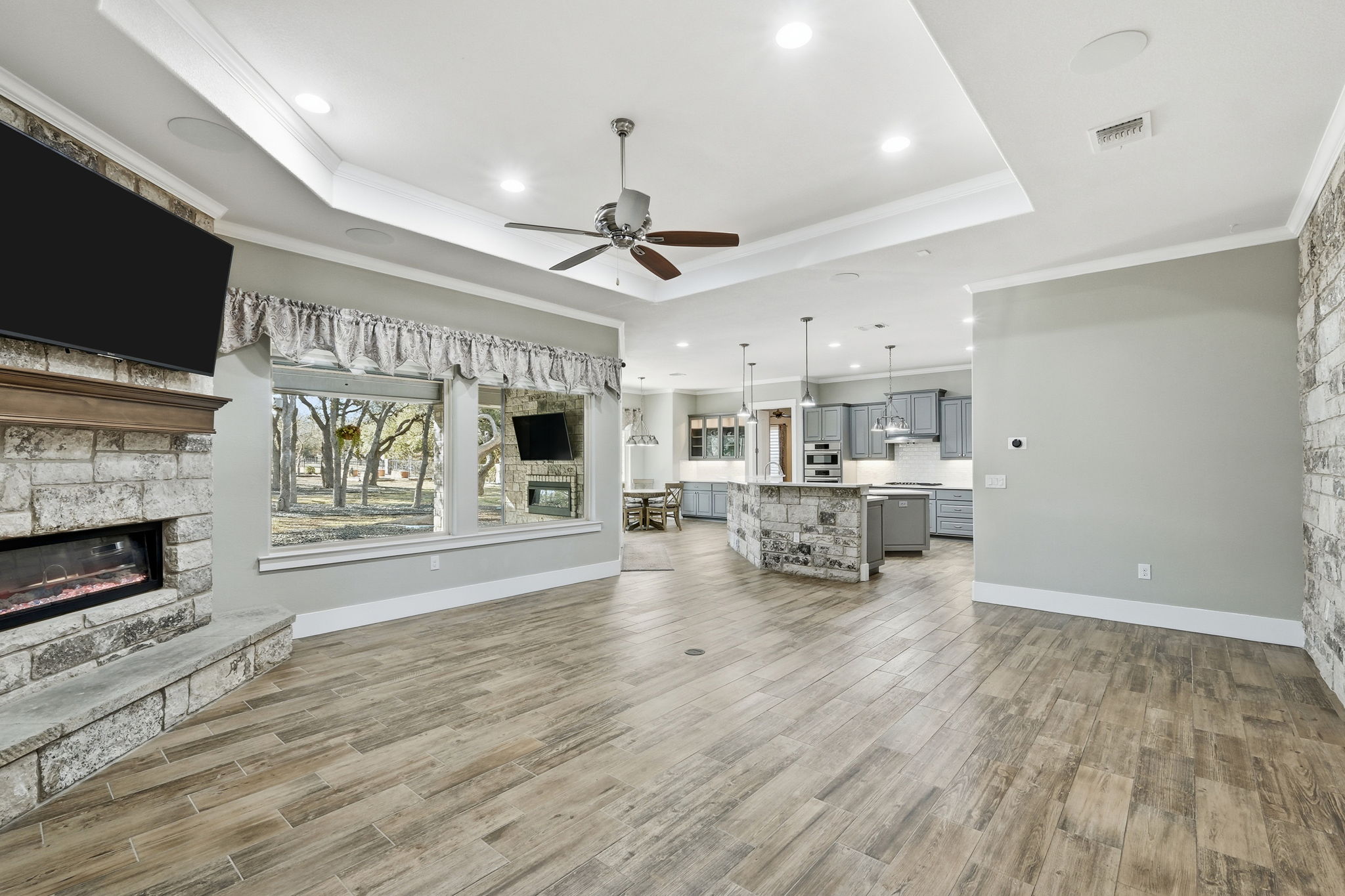 403 Highland Spring Lane Georgetown, TX 78633 - Photo 11 of 40 Living room featuring a fireplace, ceiling fan, light wood-style floors, ornamental molding, and recessed lighting