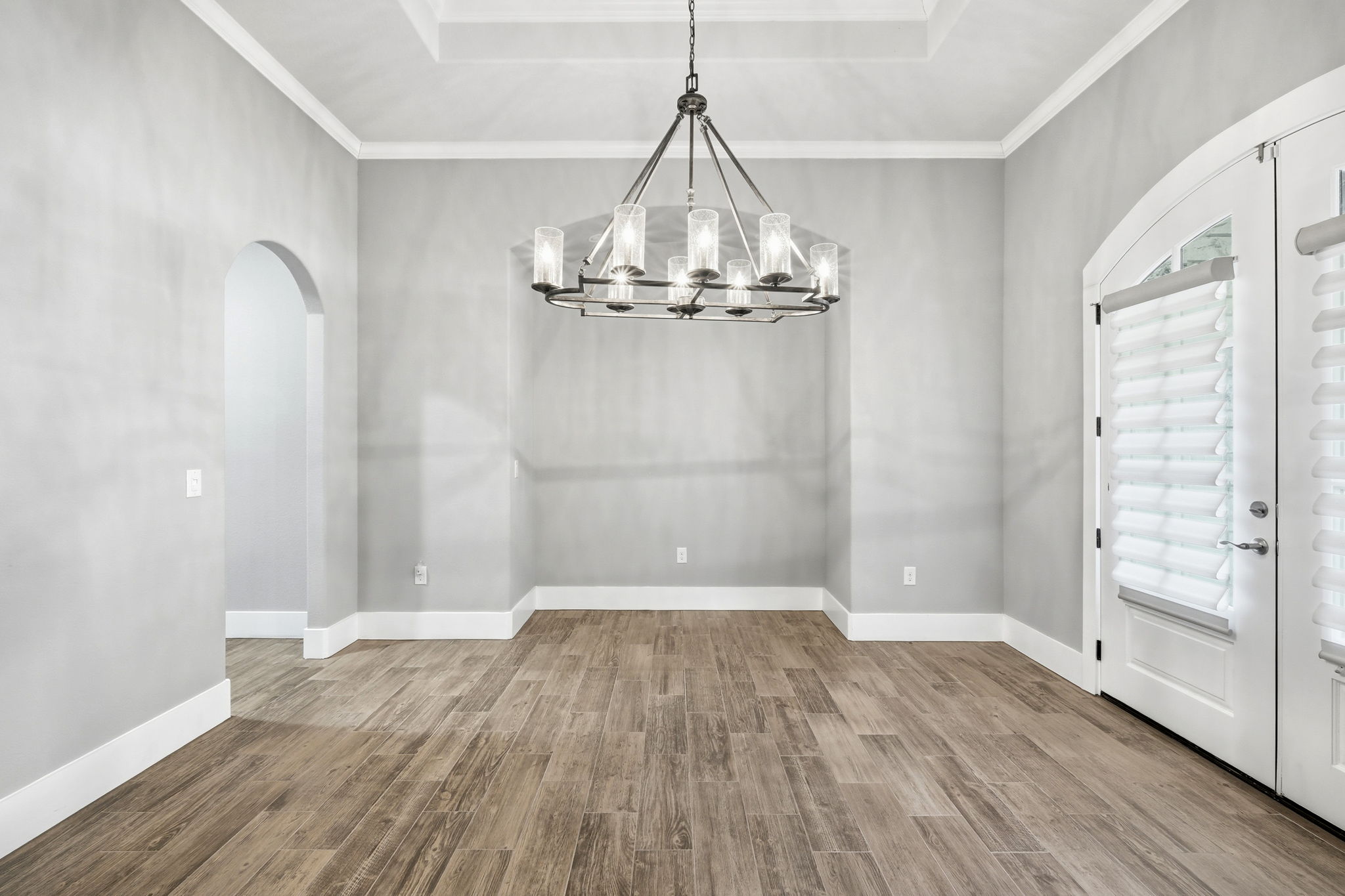 403 Highland Spring Lane Georgetown, TX 78633 - Photo 16 of 40 Unfurnished dining area with arched walkways, light wood-type flooring, and crown molding