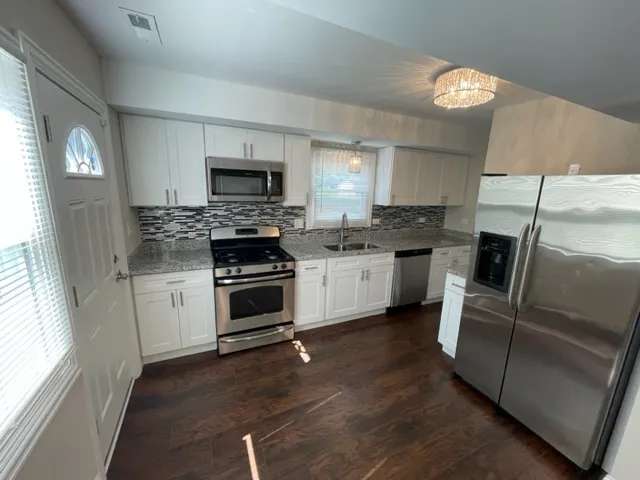 a kitchen with cabinets stainless steel appliances and a window