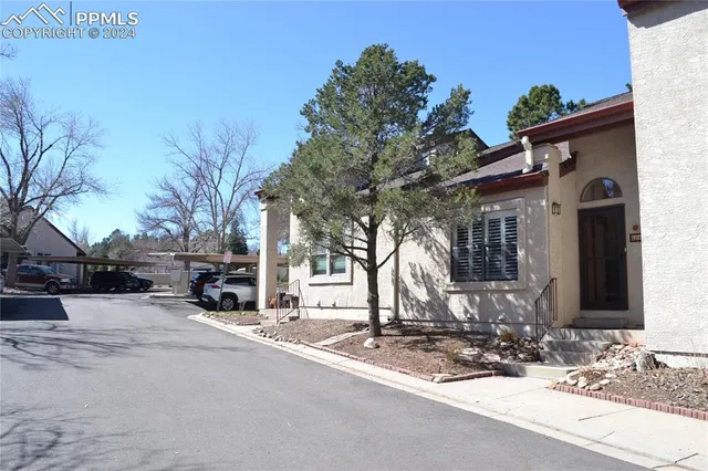 a front view of a house with cars parked