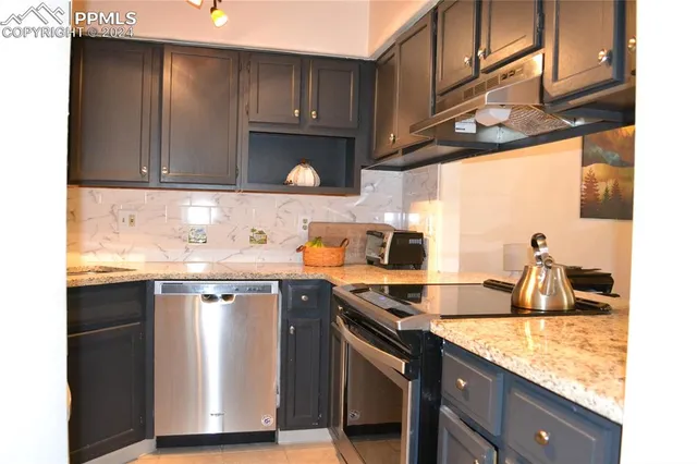 a kitchen with granite countertop a sink a stove and cabinets