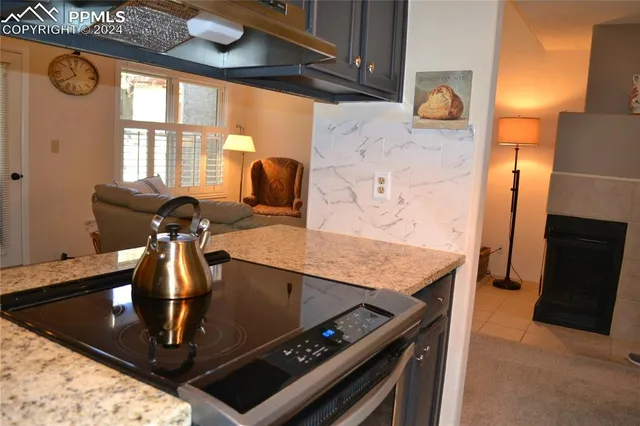 a view of a kitchen with a stove a fridge and wooden floor