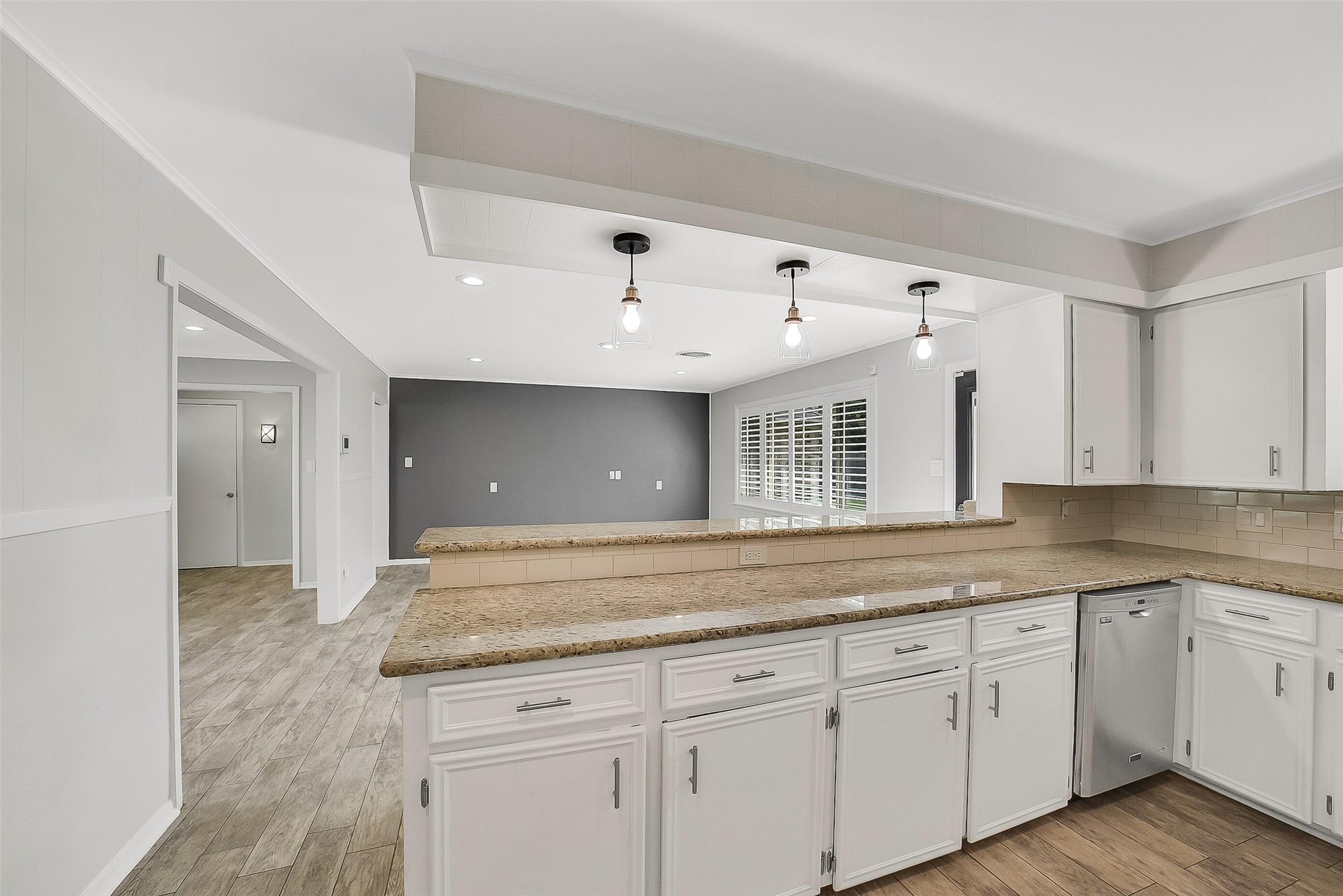 10135 Knoboak Drive Houston, TX 77080 - Photo 12 of 26 Another angle showcases the three pendant lights above the counter, enhancing both style and function. Together with ample cabinetry and a clean, connected flow, the kitchen serves as the true centerpiece of the home.
