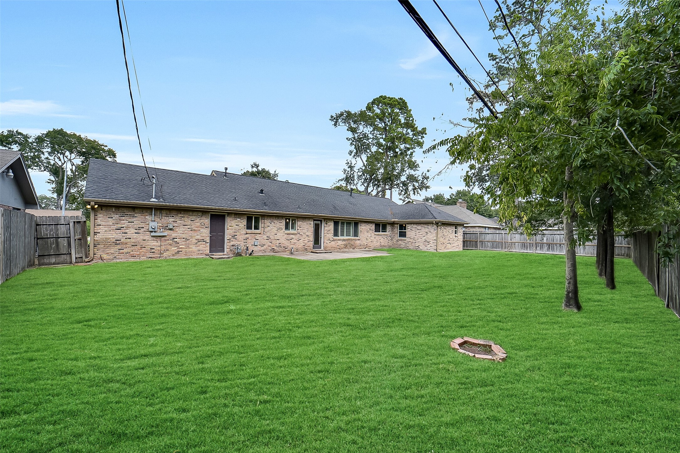 10135 Knoboak Drive Houston, TX 77080 - Photo 25 of 26 Expansive backyard with trees lining the back fence, creating a natural backdrop and added privacy. A concrete patio off the backdoor is perfectly sized for outdoor furniture, making it an ideal spot for grilling or dining al fresco.