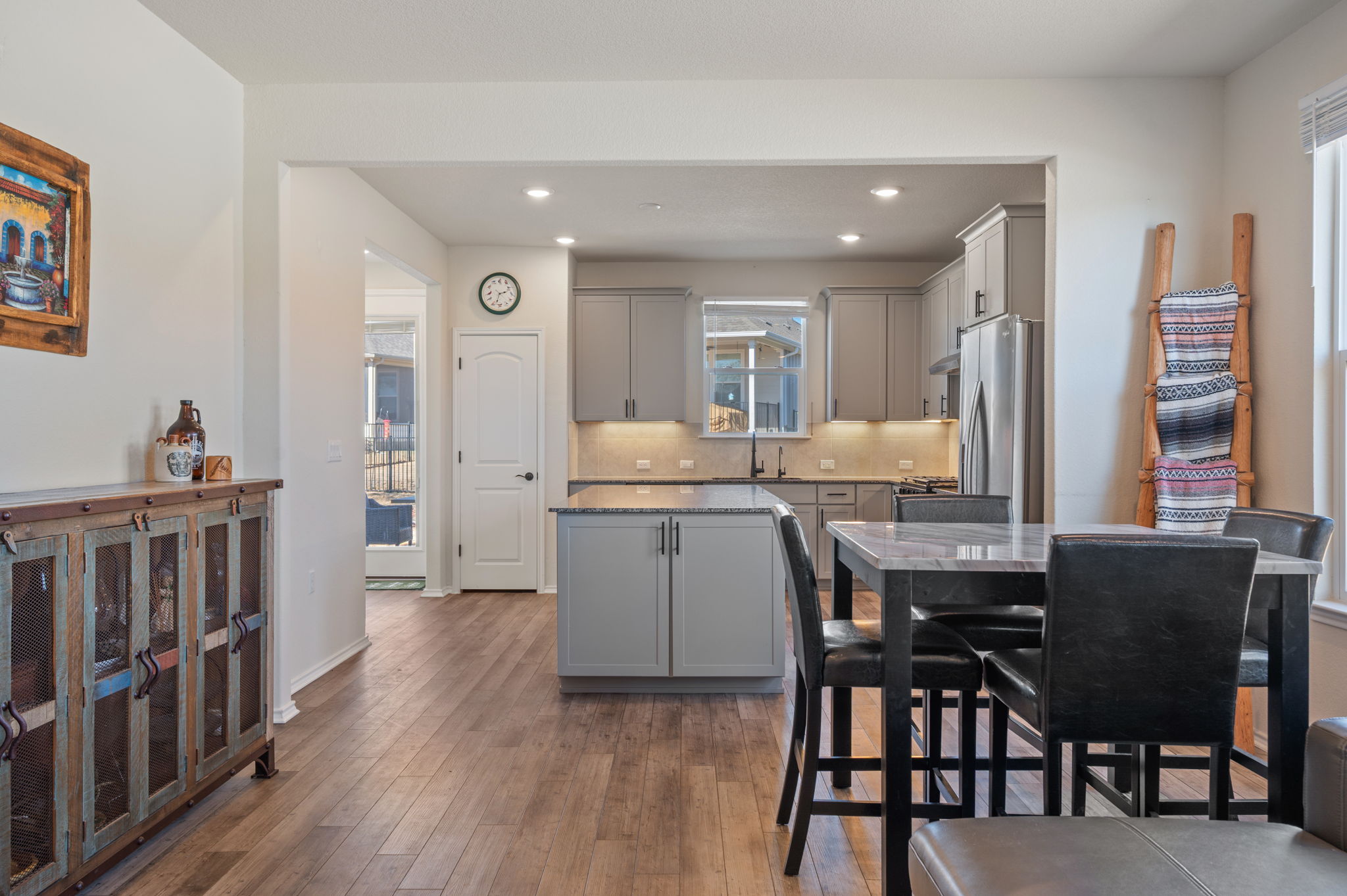 100 Bristol Cove Georgetown, TX 78633 - Photo 12 of 31 a kitchen with kitchen island granite countertop wooden floors and white cabinets