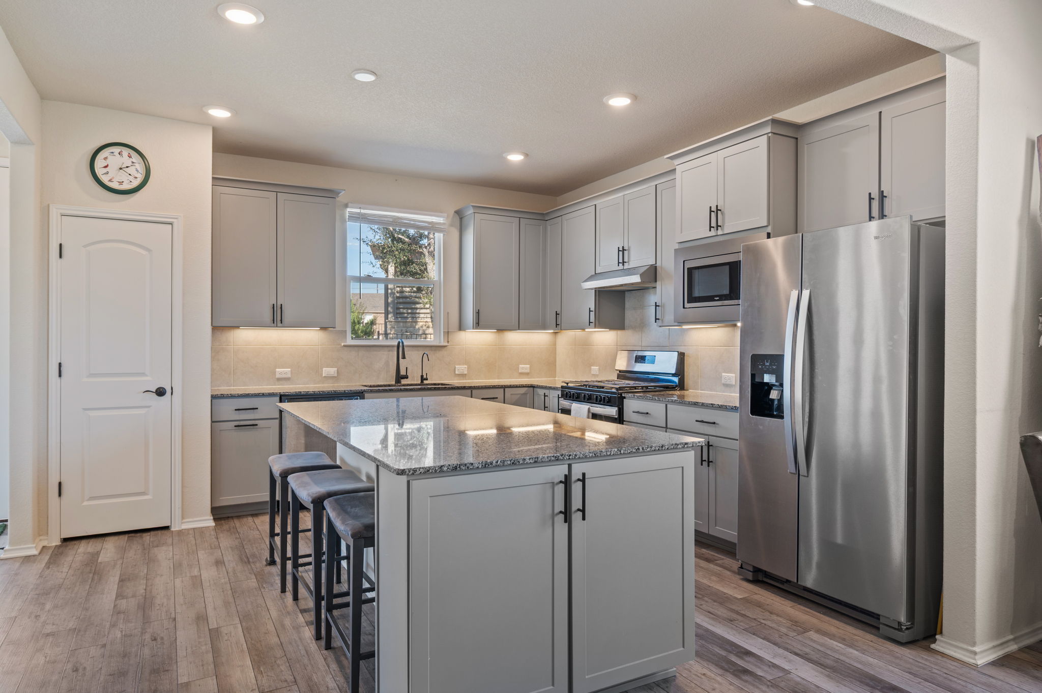 100 Bristol Cove Georgetown, TX 78633 - Photo 5 of 31 a kitchen with kitchen island a refrigerator stove microwave and cabinets