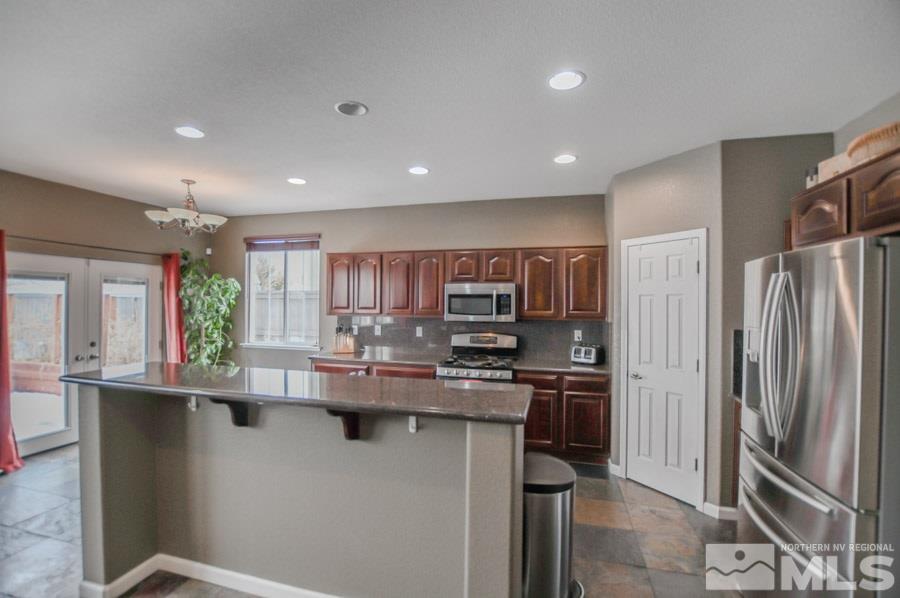 455 Ruffian Court Reno, NV 89521 - Photo 3 of 25 a kitchen with kitchen island stainless steel appliances a sink stove and refrigerator