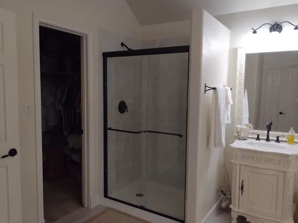 a bathroom with a shower a sink and a mirror