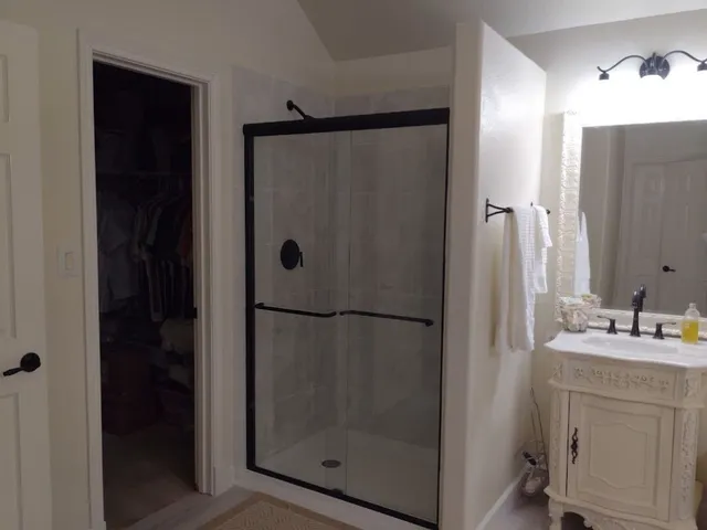 a bathroom with a shower a sink and a mirror