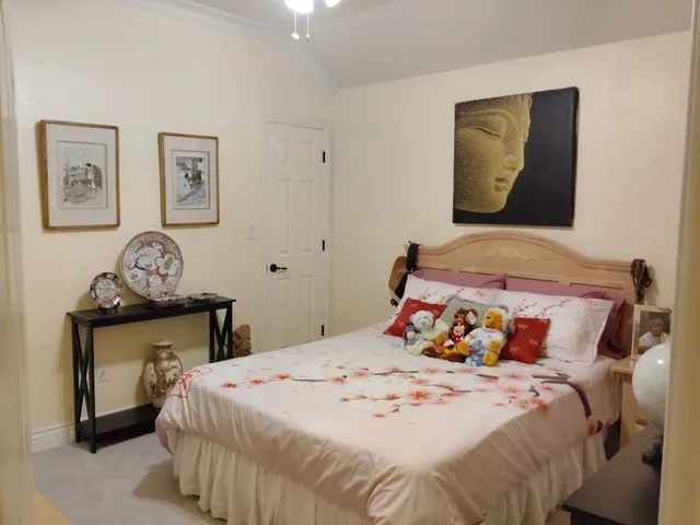 a bedroom with a bed and painting on the wall