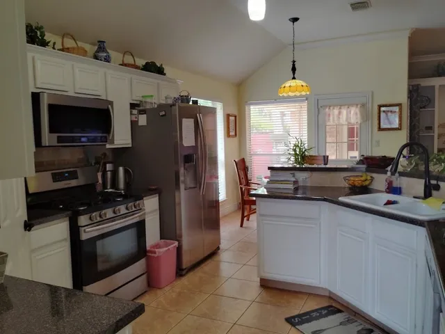 a kitchen with a sink stainless steel appliances a counter space and a window