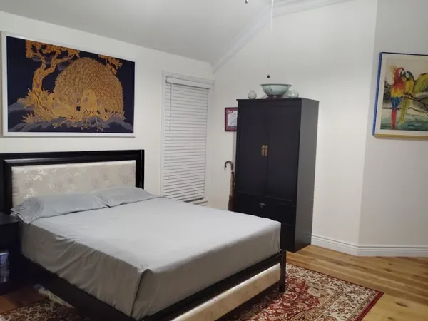 a bedroom with a bed and wall painting