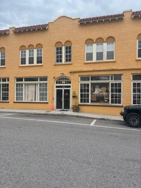 a front view of a house with a yard and parking space