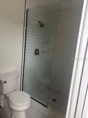 a bathroom with a toilet and a shower