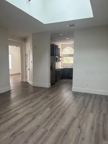 wooden floor in an empty room with a kitchen