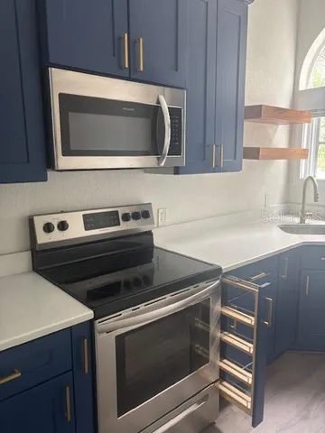 a kitchen with a stove microwave and sink