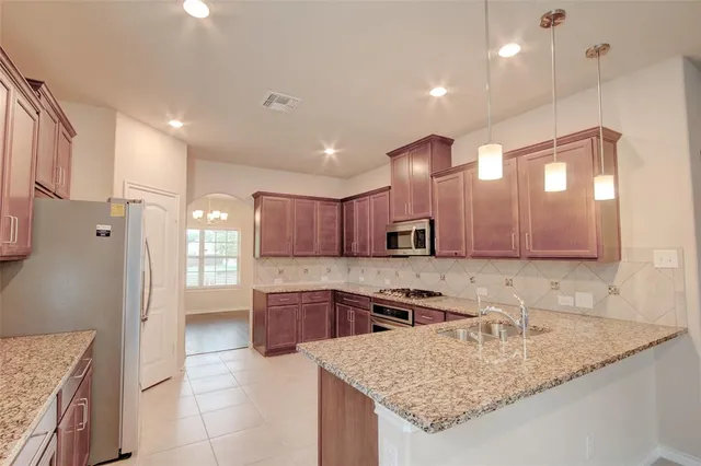 a kitchen with stainless steel appliances granite countertop a sink stove and refrigerator