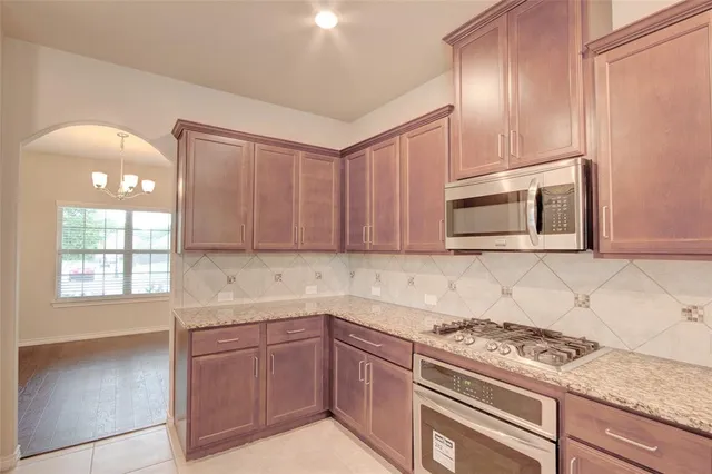 a kitchen with granite countertop a stove sink and microwave