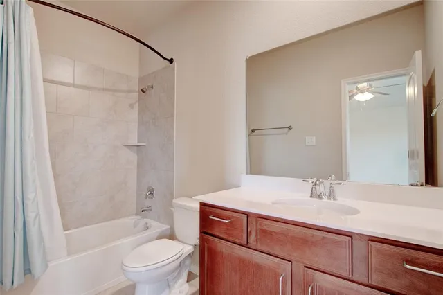 a bathroom with a granite countertop sink a toilet and shower